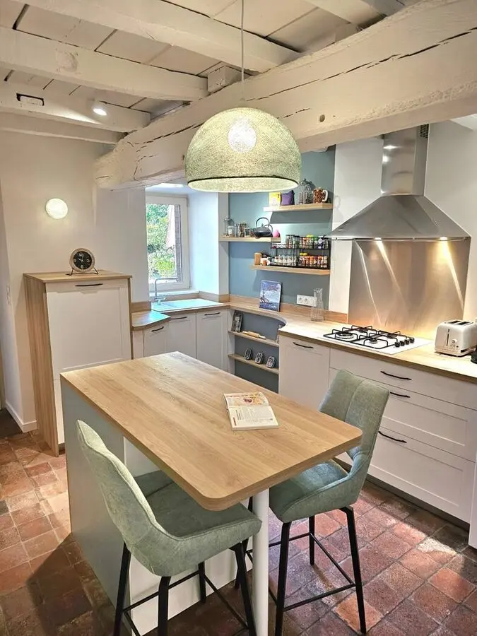 Cuisine terminée avec table centrale et chaises vertes